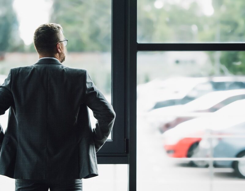 Male employer looking out the window contemplating about ATO crackdown on car in 2025 FBT year