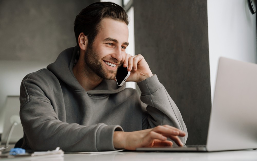 Businessman talking on the phone while using calendly as one of apps for small businesses