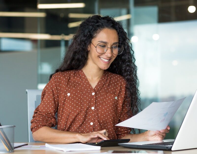 Businesswoman smiles while checking for tax deductions
