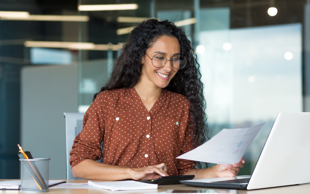 Businesswoman smiles while checking for tax deductions